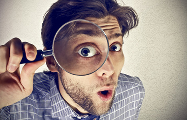 Poslovni čovjek gleda kroz povećalo