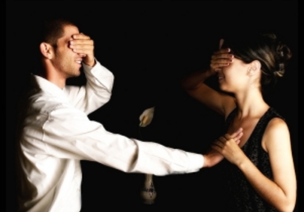 Momak i devojka drže ruke na očima