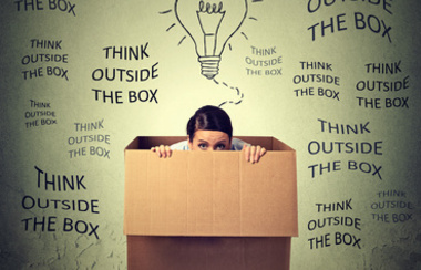 Razmišljajte izvan okvira. Uplašena mlada žena sjedi unutar kutije.