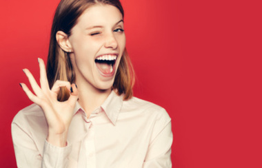 Djevojka namiguje i pokazuje gestu u redu