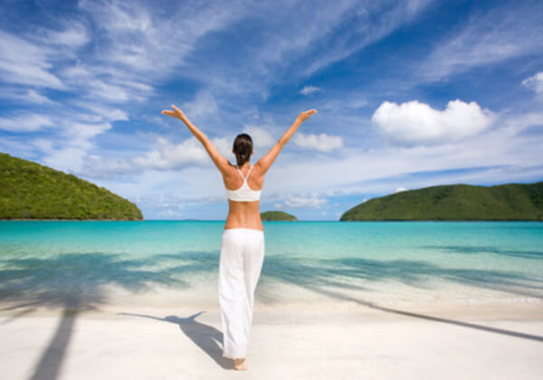 Žena na plaži sa raširenim rukama