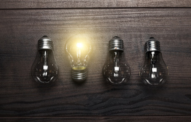 Koncept jedinstvenosti užarene žarulje na drvenoj pozadini