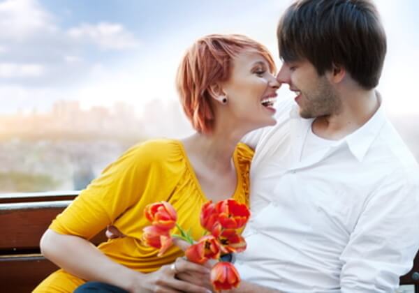 Dvoje mladih na klupi sa cvećem